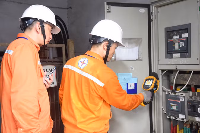 Công nhân Công ty Điện lực Hoàn Kiếm kiểm tra nhiệt độ tại trạm biến áp Trường THPT Việt Đức