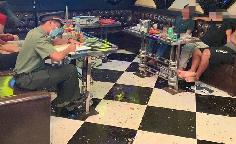 Tổ công tác Công an thị xã Quảng Yên lập biên bản vi phạm hành chính đối với chủ quán karaoke và những người vi phạm quy định phòng, chống dịch