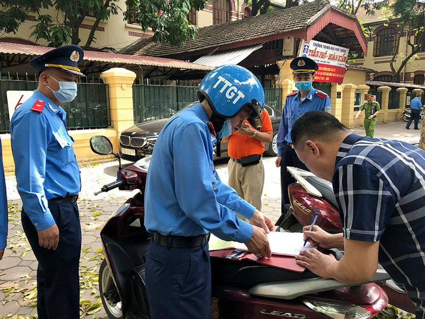 Tổ công tác lập biên bản xử lý một trường hợp vi phạm đỗ xe trên vỉa hè trước cửa số 8 Hai Bà Trưng