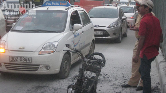 Chiếc xe bị thiêu rụi, trơ khung sắt được người dân khiêng vào vỉa hè