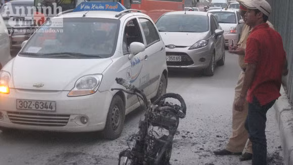 Chiếc xe bị thiêu rụi, trơ khung sắt được người dân khiêng vào vỉa hè
