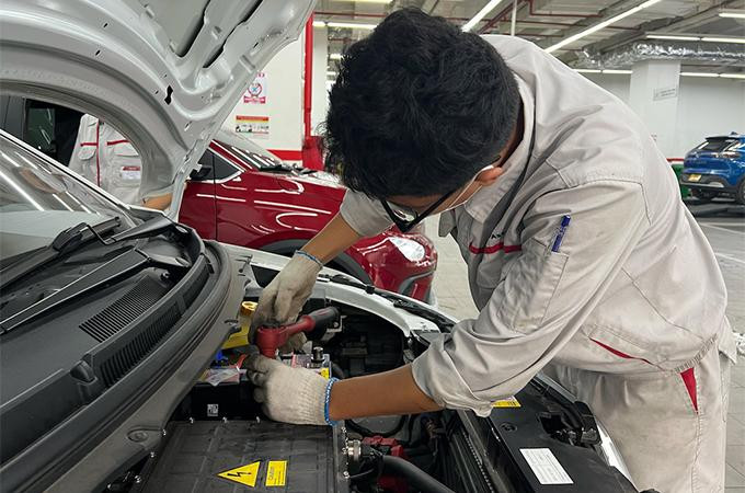 Kỹ thuật viên VinFast đang thay thế ắc quy mới cho khách hàng.