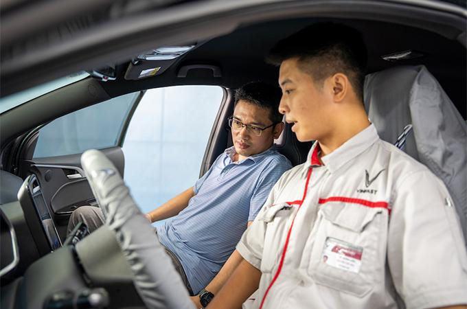 Anh Phan Xuân Hải đang trao đổi với kỹ thuật viên VinFast trong quá trình cập nhật phần mềm cho xe VF e34.