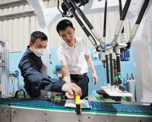 Anh Thái Bình Dương - Trưởng ban Cải tiến Nhà máy sữa TH và đồng nghiệp đang nghiên cứu, chế tạo robot gắp bịch sữa
