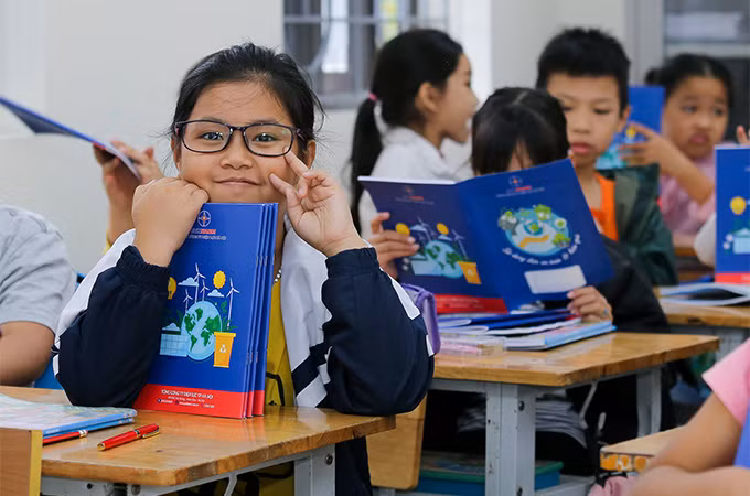 Các em học sinh thích thú khi nhận những cuốn vở