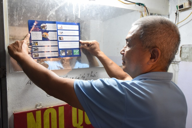 Ông Vương Văn Thành dán nội dung khuyến cáo để nhắc nhở khách thuê trọ trong việc sử dụng điện an toàn và PCCC