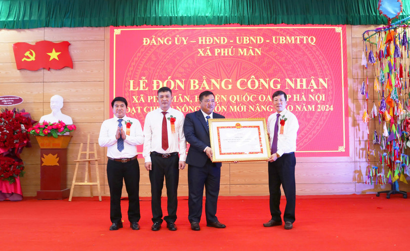 Ông Đàm Công Lợi - Phó Bí thư Thường trực huyện ủy Quốc Oai (phải) trao Bằng công nhận đạt chuẩn nông thôn mới nâng cao cho xã Phú Mãn