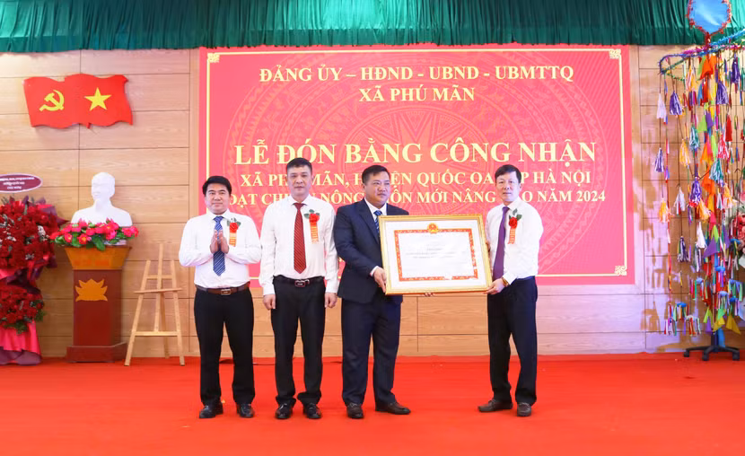 Ông Đàm Công Lợi - Phó Bí thư Thường trực huyện ủy Quốc Oai (phải) trao Bằng công nhận đạt chuẩn nông thôn mới nâng cao cho xã Phú Mãn Ông Đàm Công Lợi - Phó Bí thư Thường trực huyện ủy Quốc Oai (phải) trao Bằng công nhận đạt chuẩn nông thôn mới nâng cao cho xã Phú Mãn
