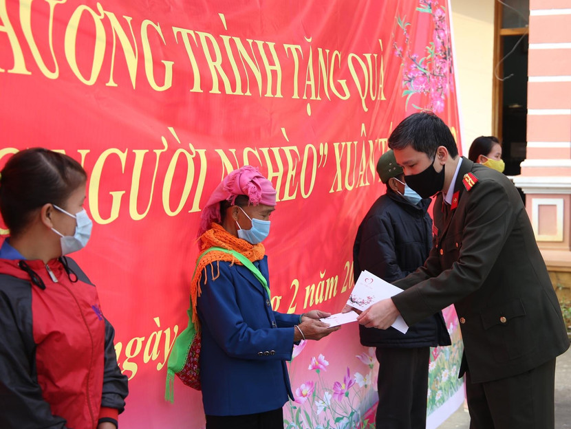 Thiếu tá Vũ Mạnh Hùng - Phó Tổng Biên tập Báo ANTĐ thay mặt Quỹ Thiện Tâm của Tập đoàn Vingroup trao từng suất quà đến tận tay bà con nghèo