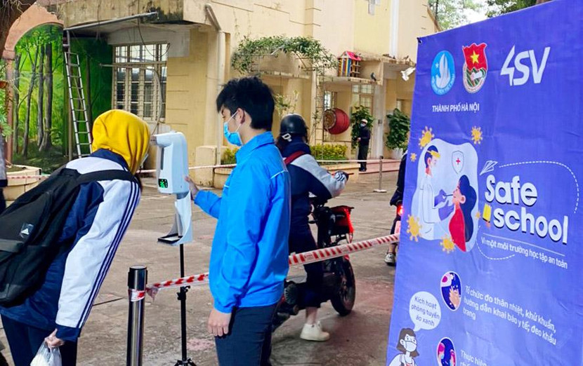 Thanh niên tình nguyện hỗ trợ đo thân nhiệt, khử khuẩn, hướng dẫn khai báo y tế tại cổng trường học Thanh niên tình nguyện hỗ trợ đo thân nhiệt, khử khuẩn, hướng dẫn khai báo y tế tại cổng trường học