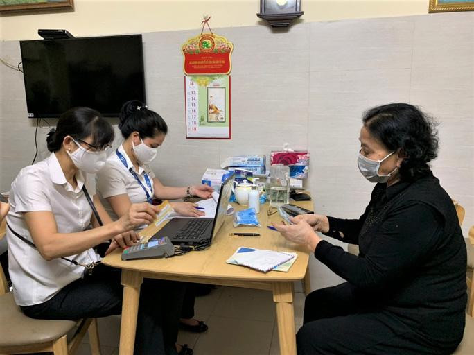 Cán bộ bưu điện TP.Hà Nội chi trả lương hưu cho người dân