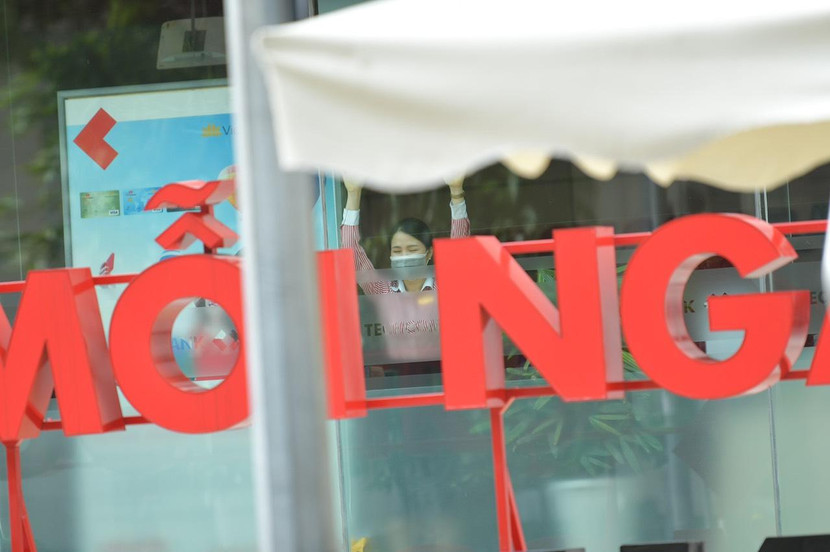 Nhân viên một đơn vị có trụ sở trong Vincom Bà Triệu nhìn ra cửa trong lúc lực lượng chức năng phong tỏa khu vực này