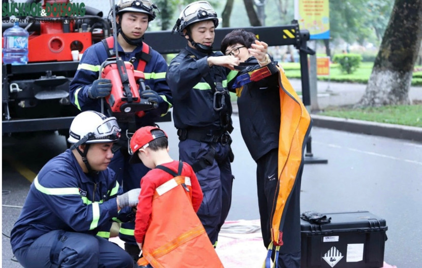 Hình ảnh các CBCS đang hướng dẫn người dân thao tác buộc dây đai cứu hộ cứu người trên cao