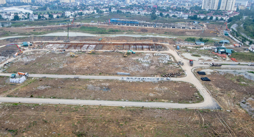 Trên công trường, các khu đất đang được san nền, bóc tách và tạo hình mặt bằng, chuẩn bị cho hệ thống đường nội bộ và các tiện ích mặt nước.