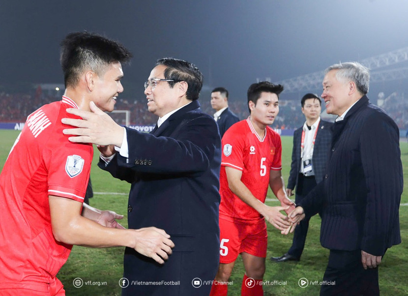 Thủ tướng Phạm Minh Chính cùng Phó Thủ tướng Thường trực Nguyễn Hoà Bình (bên phải) chia vui cùng các thành viên ĐT Việt Nam