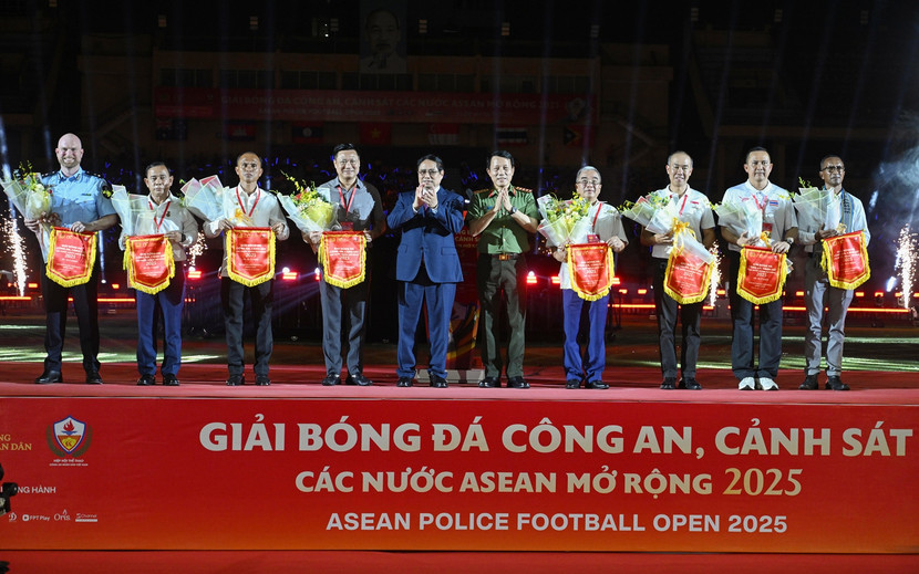 Thủ tướng Phạm Minh Chính (thứ năm từ trái qua) và Bộ trưởng Bộ Công an Lương Tam Quang (thứ năm từ phải qua) trao tặng hoa và cờ lưu niệm cho đại diện các đội tham dự giải