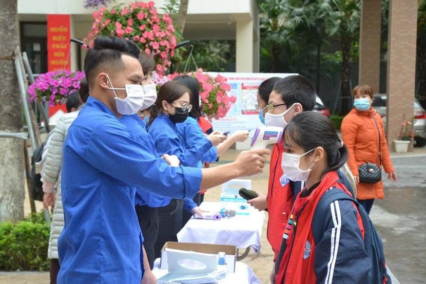 Đoàn viên, thanh niên hỗ trợ đo thân nhiệt cho học sinh trong ngày đầu quay lại trường học