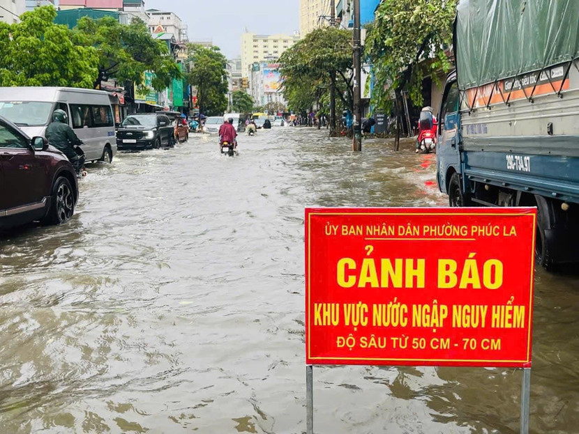 Lực lượng chức năng đặt biển cảnh báo tại các điểm ngập ở Hà Đông