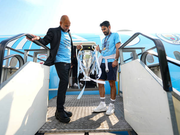 HLV Pep Guardiola và đội trưởng Gundogan mang cúp đặt chân xuống Manchester HLV Pep Guardiola và đội trưởng Gundogan mang cúp đặt chân xuống Manchester