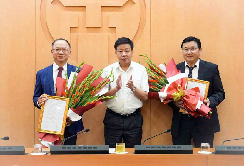 Phó Chủ tịch UBND TP Hà Nội Dương Đức Tuấn trao quyết định và tặng hoa chúc mừng tân Phó Chánh Văn phòng UBND TP và Phó Giám đốc Sở Quy hoạch - Kiến trúc