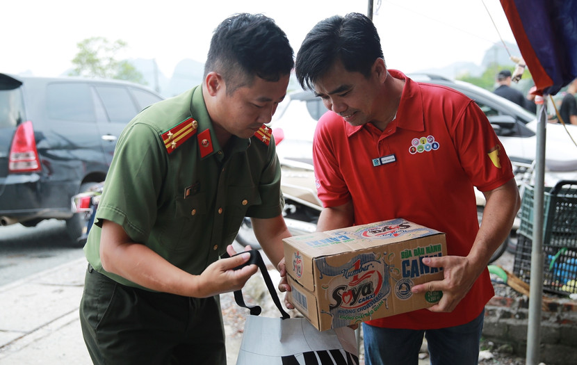 Trung tá Chu Quốc Dũng - Phó trưởng Ban Biên tập An ninh Thủ đô cùng đại diện Tập đoàn Tân Hiệp Phát chuẩn bị những phần quà cho bà con