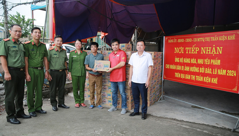 Đoàn công tác Báo An ninh Thủ đô do Trung tá Chu Quốc Dũng (thứ ba từ trái qua) dẫn đầu trao 250 thùng sữa đậu nành Soya Number 1 của Tập đoàn Tân Hiệp Phát cho đại diện chính quyền thị trấn Kiện Khê, Thanh Liêm, Hà Nam