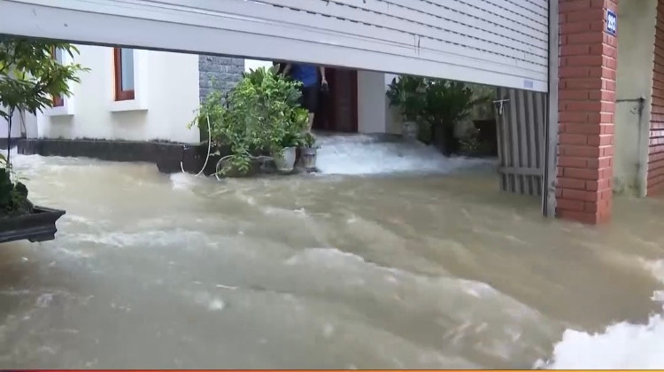 Nước chảy xiết qua nhà dân