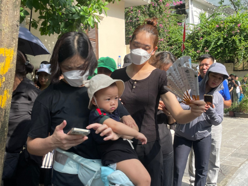 Một cháu bé cùng mẹ đi tiễn biệt Tổng Bí thư lần cuối