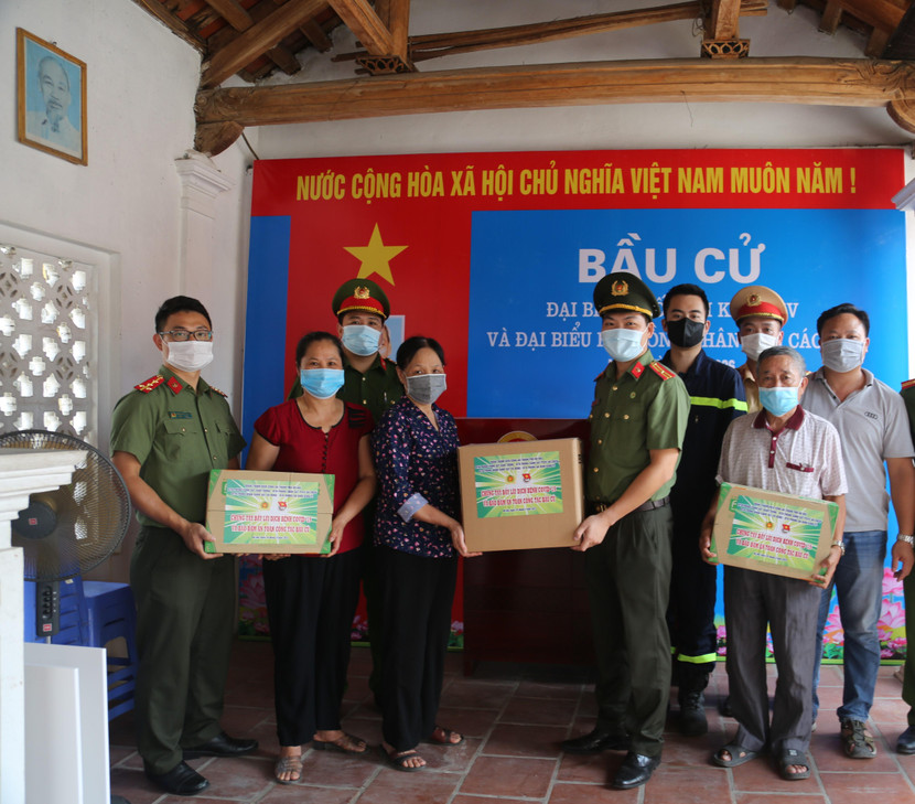 Thiếu tá Đỗ Xuân Chi, Phó Bí thư Đoàn Thanh niên CATP tặng vật tư chống dịch cho điểm bầu cử Cầu Gạo, thôn 1, xã Lại Yên, Hoài Đức