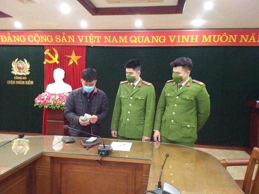 Anh Long vui mừng nhận lại số tiền đánh rơi được các chiến sỹ CAQ Hoàn Kiếm nhặt được, trao lại