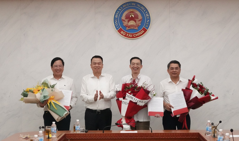 Thứ trưởng Bộ Tài chính Nguyễn Đức Chi trao quyết định và tặng hoa cho các cán bộ lãnh đạo vừa được bổ nhiệm