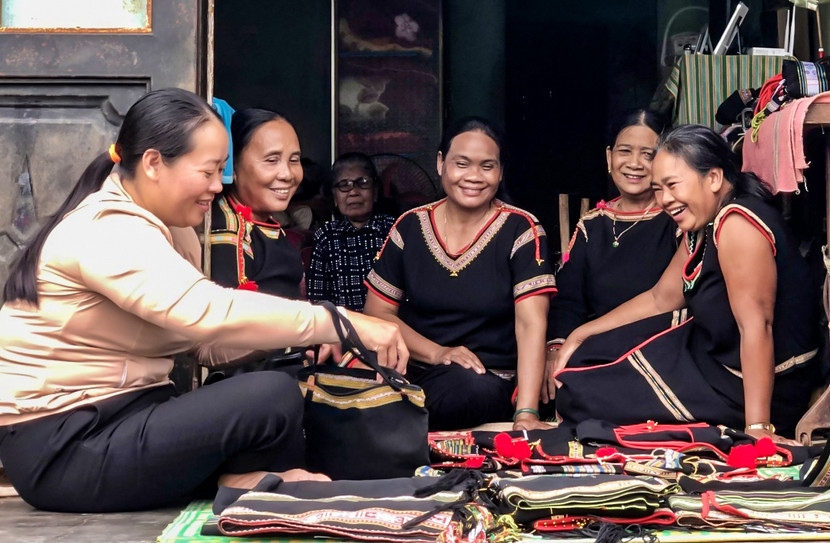 Bà H'Yar Kbuôr cùng các chị em trong Tổ hợp tác dệt thổ cẩm buôn Kla giới thiệu các sản phẩm của mình