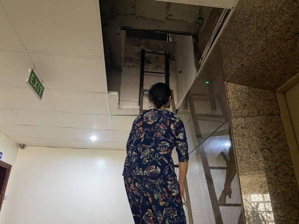 Lối thoát hiểm lên mái của tòa nhà chỉ là 1 lỗ nhỏ 1 người chui vừa Lối thoát hiểm lên mái của tòa nhà chỉ là 1 lỗ nhỏ 1 người chui vừa