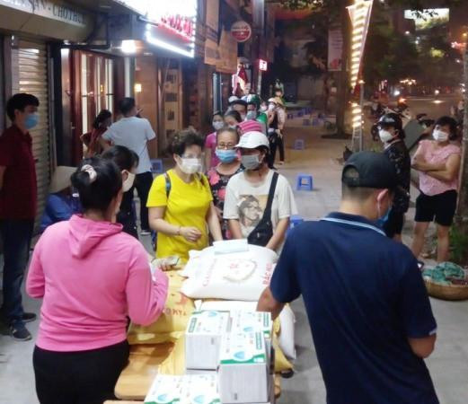 Khá đông người lao động có hoàn cảnh khó khăn đến quán ăn của bà Thành ở phố Tây Sơn để nhận tiền, gạo hỗ trợ