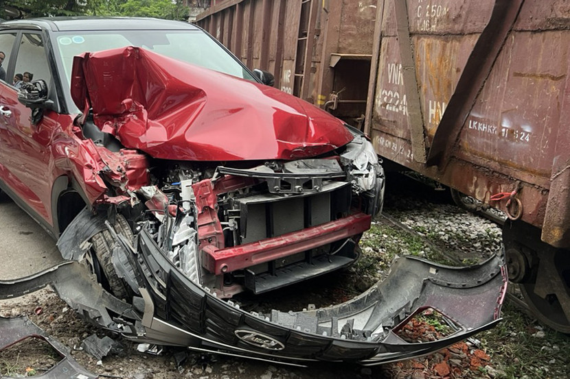 Chiếc xe ô tô đỗ sát đường tàu đã bị tàu hoả đâm trúng làm hư hỏng nặng phần đầu xe