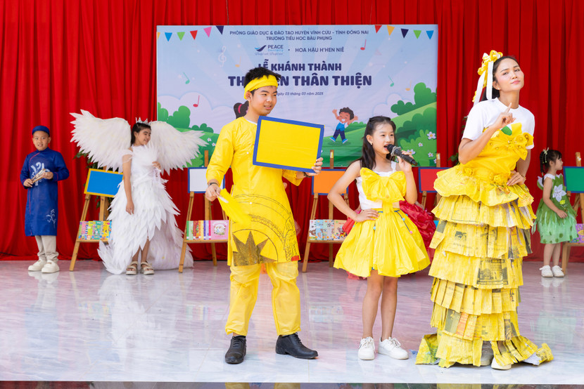 Cô mặc trang phục mã màu vàng dành cho học sinh khối lớp 5 với những quyển sách cung cấp kiến thức với ít tranh minh hoạ. Không phải là bộ trang phục lấp lánh kiêu sa thường thấy, H’Hen Niê diện bộ đầm bằng giấy báo cũ do các em học sinh thiết kế