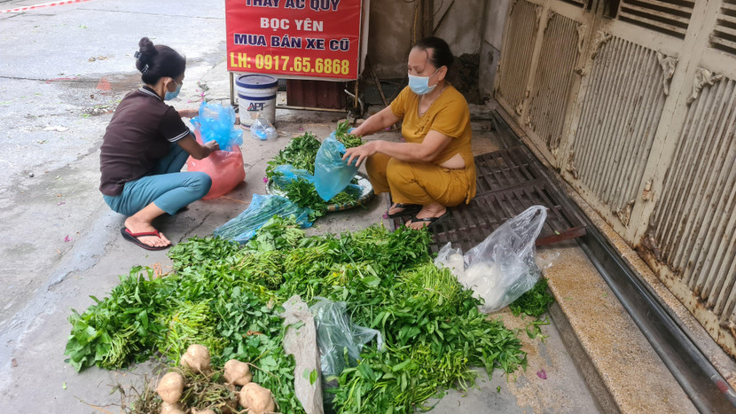 Cán bộ Hội phụ nữ và Cụm dân cư số 6, phường Tân Mai chia các phần rau, củ cho bà con bị cách ly, phong tỏa do dịch Covid-19 trên địa bàn