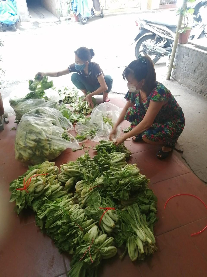 Đại diện Hội phụ nữ phường Tân Mai chia dưa xanh cho bà con đang bị phong tỏa, cách ly do dịch Covid-19