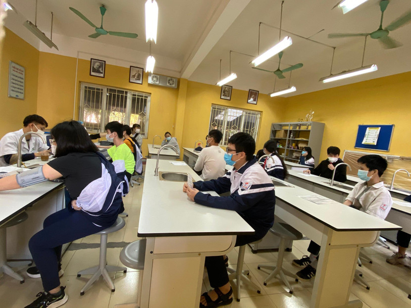 Học sinh ngồi chờ khám sàng lọc trước tiêm Học sinh ngồi chờ khám sàng lọc trước tiêm