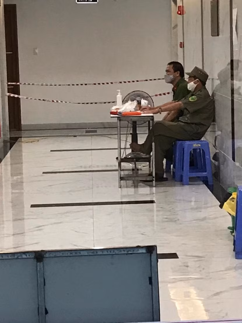 Sau 3 ngày, tòa nhà được thu hẹp phạm vi phong tỏa, chỉ còn trên tầng 10, nơi cư trú của bệnh nhân nhiễm Covid-19. Và, vẫn không thể thiếu sắc phục màu xanh