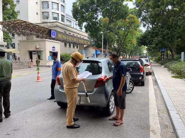 Kiểm tra giấy tờ và lý do ra đường của người điểu khiển ô tô Nhân viên y tế phường Bạch Đằng đối chiếu thông tin công dân