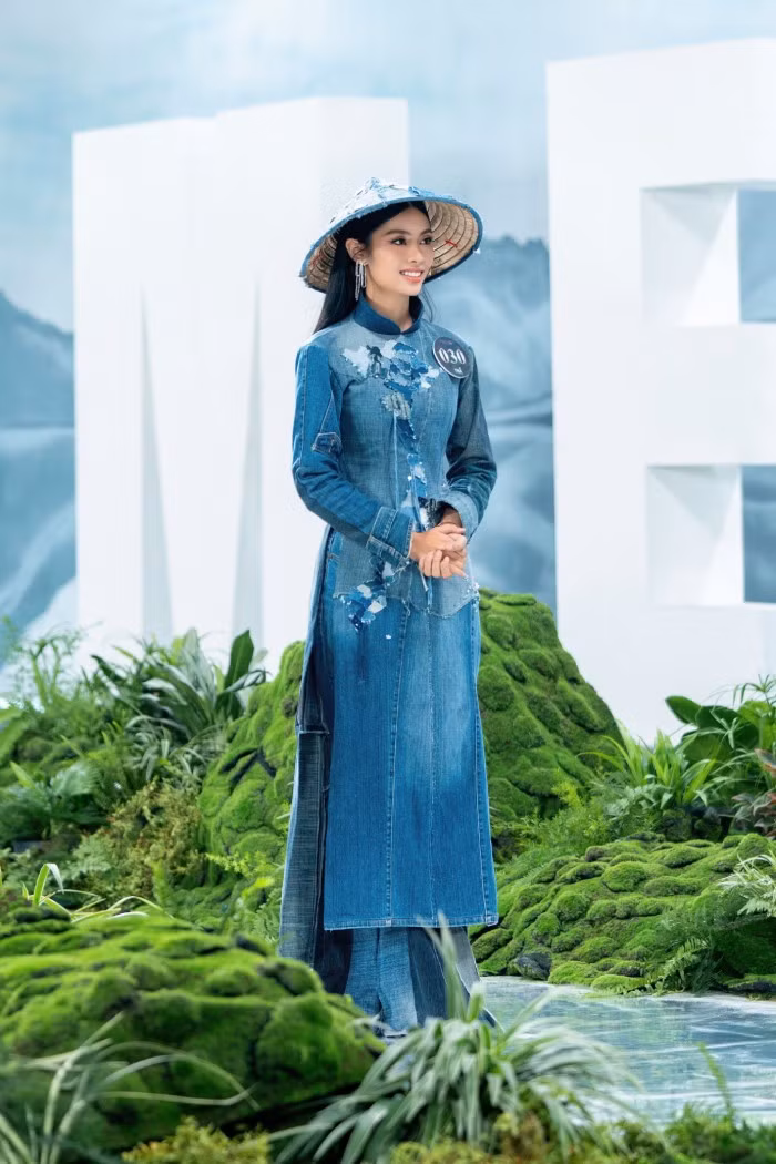 Một chiếc áo dài với tên gọi Việt Nam in denim mang đến một vẻ đẹp táo bạo cho trang phục truyền thống của Việt Nam được mặc bởi thí sinh Nguyễn Thị Quỳnh Trang. Mẫu trang phục này được làm toàn bộ từ 63 mảnh vải jeans cũ…