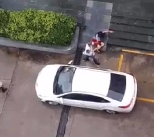 Hình ảnh người đàn ông bế em nhỏ liên tục đánh đấm người phụ nữ được cắt từ clip Hình ảnh người đàn ông bế em nhỏ liên tục đánh đấm người phụ nữ được cắt từ clip