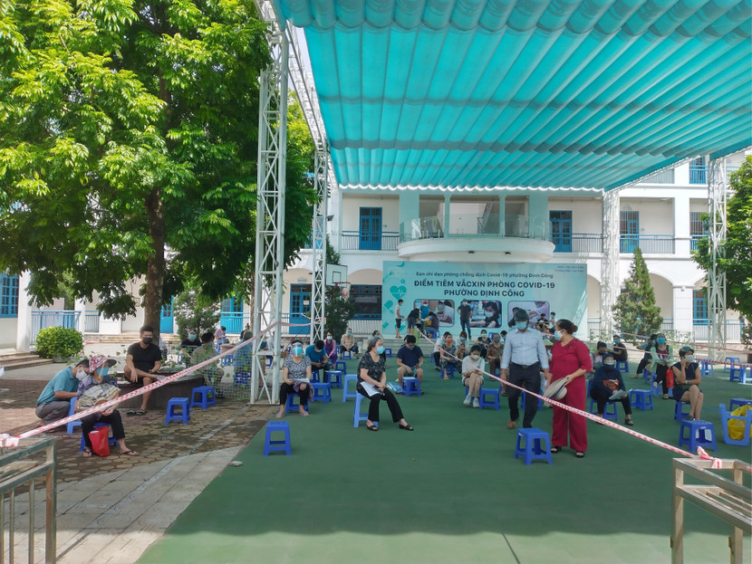 Khu vực xếp hàng, chờ xét nghiệm, tiêm chủng tại phường Định Công. Dự kiến đợt này, phường Định Công được phân bổ khoảng 3.900 liều vắc xin. Và tinh thần như lãnh đạo phường nêu rõ: "Có bao nhiêu vắc xin sẽ tiêm hết, tiêm đủ cho người dân"