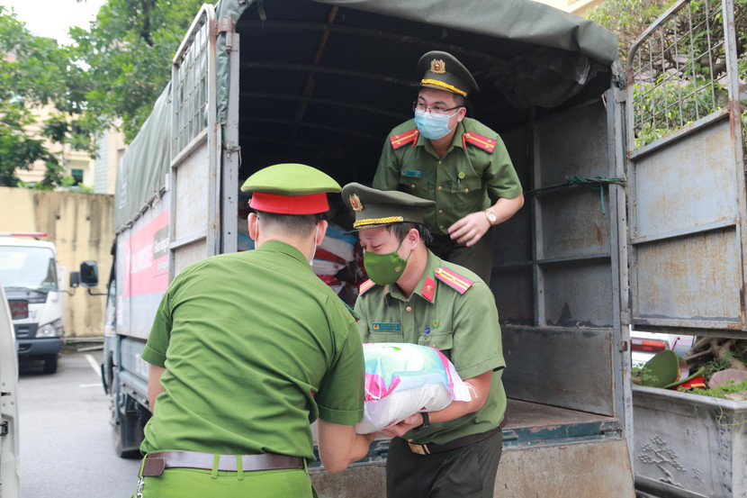 Thiếu tá Bùi Mạnh Hùng cùng đoàn viên, thanh niên CATP chuyển quà, sắp xếp hàng hóa cho chuyến thiện nguyện