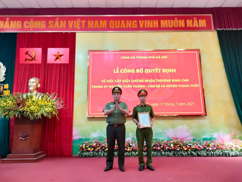 Trung tướng Nguyễn Hải Trung, Giám đốc CATP Hà Nội trao Giấy chứng nhận thương binh cho Trung úy Nguyễn Tuấn Thành