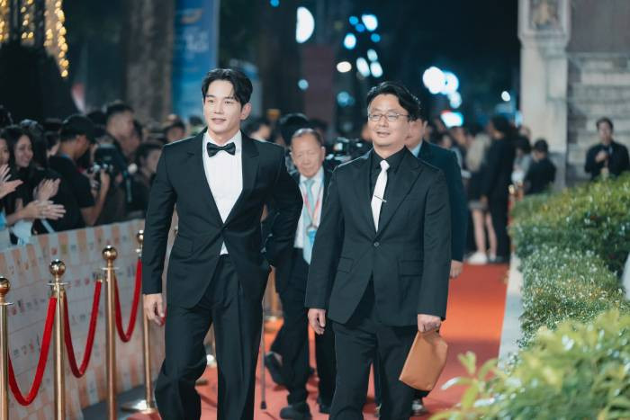 Xuất hiện tại thảm đỏ cùng với đoàn nghệ sĩ và các nhà làm phim Hàn Quốc là diễn viên On Joo-Wan (trái). Tài tử phim "The Penthouse" (Cuộc chiến thượng lưu) diện vest đen lịch lãm. Anh hào hứng giao lưu cùng khán giả hâm mộ và còn tạo dáng “bắn tim” vui vẻ