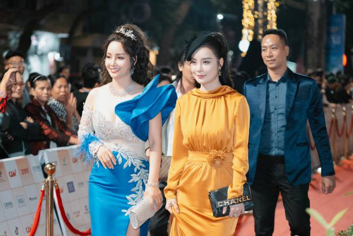 Diễn viên, đạo diễn Mai Thu Huyền có mặt từ rất sớm với chiếc đầm dạ hội thiết kế bất đối xứng, phối hai màu xanh dương và trắng khá cầu kỳ. Phần ngực váy và một bên tay là vải ren có đính kết kim tuyến bắt sáng, bên còn lại dựng form 3D với những đường xếp khéo léo cùng chất liệu vải tafta của tùng váy