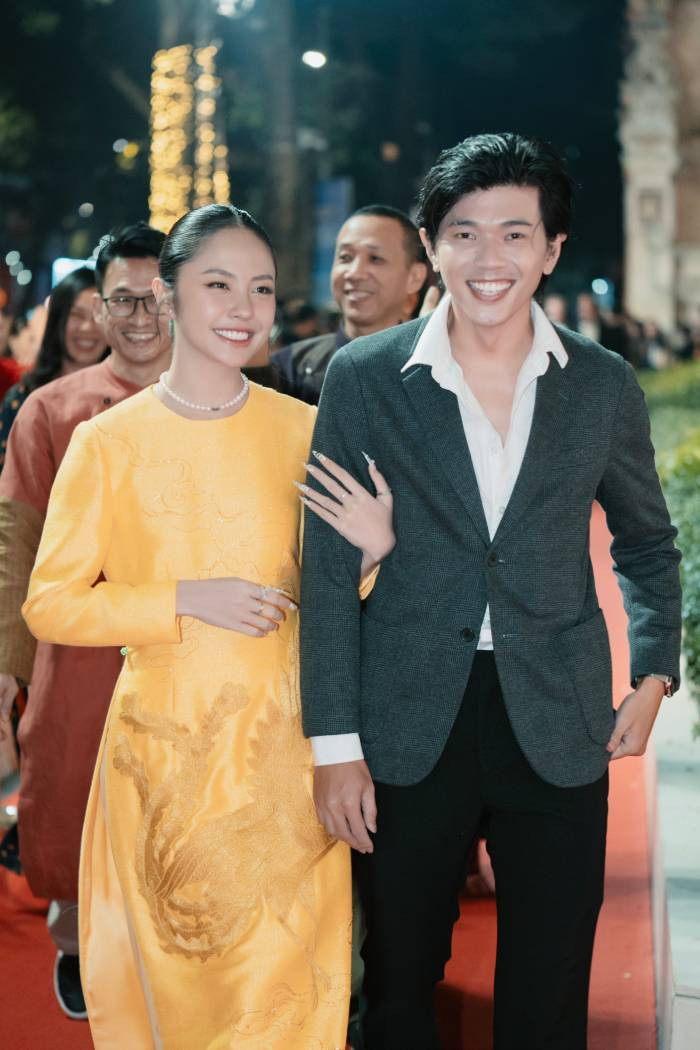 Diễn viên Rima Thanh Vy chọn chiếc áo dài kín đáo màu vàng rực rỡ với họa tiết chim phượng hoàng theo phong cách truyền thống.