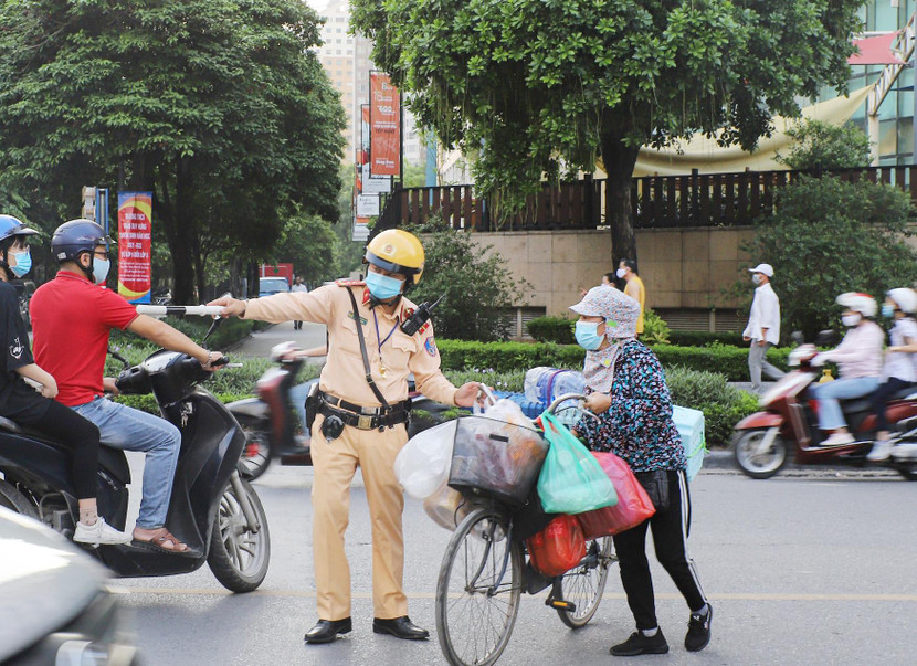 Cảnh sát giao thông Thủ đô hướng dẫn người dân qua đường không gặp nguy hiểm